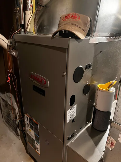Lennox furnace installation with a Midland Heating & Cooling cap resting on top
