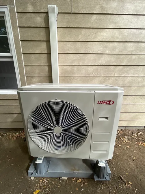 Lennox ductless mini-split outdoor heat-pump unit mounted beside a home