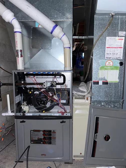 Furnace open for service showing the blower and control wiring during a tune-up