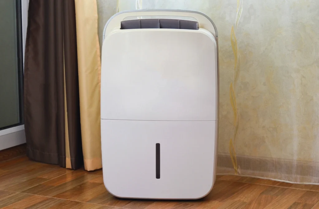 A white air conditioner placed on a polished wooden floor, showcasing its sleek design and modern appearance.