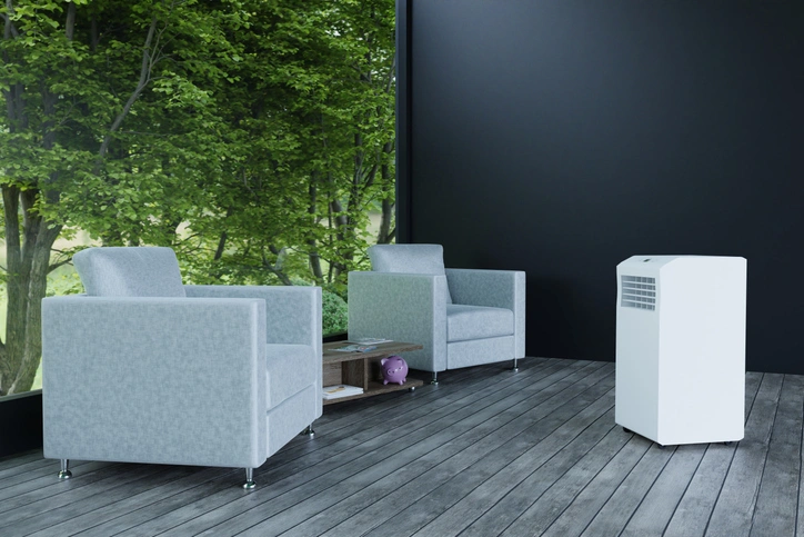 A room featuring two chairs and a white air conditioner mounted on the wall.