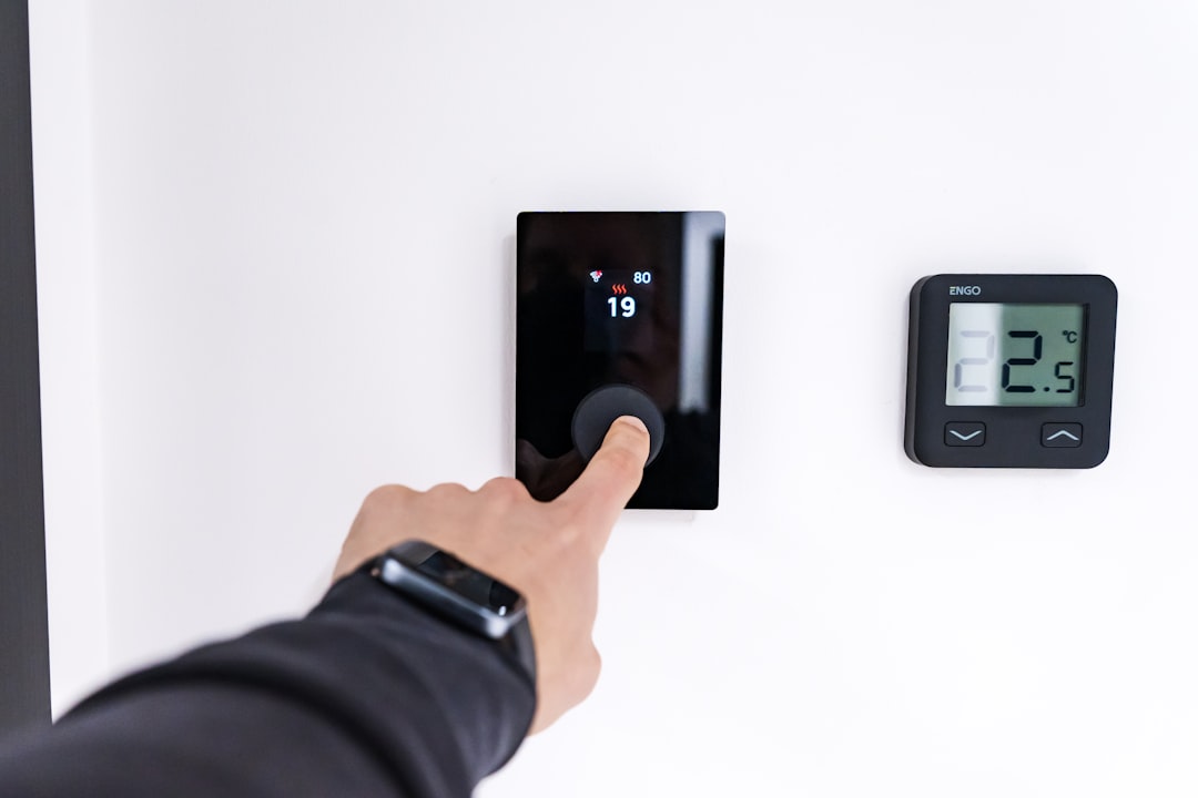 frustrated homeowner checking thermostat in a warm house