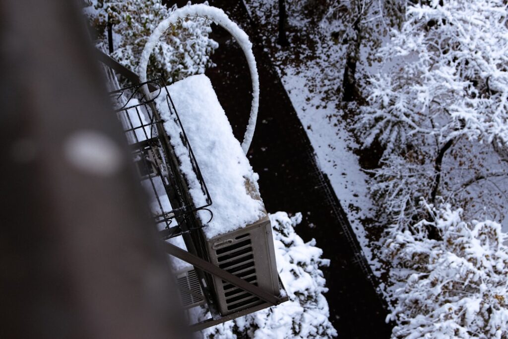 snow-covered air conditioning unit in a Twin Cities backyard in winter